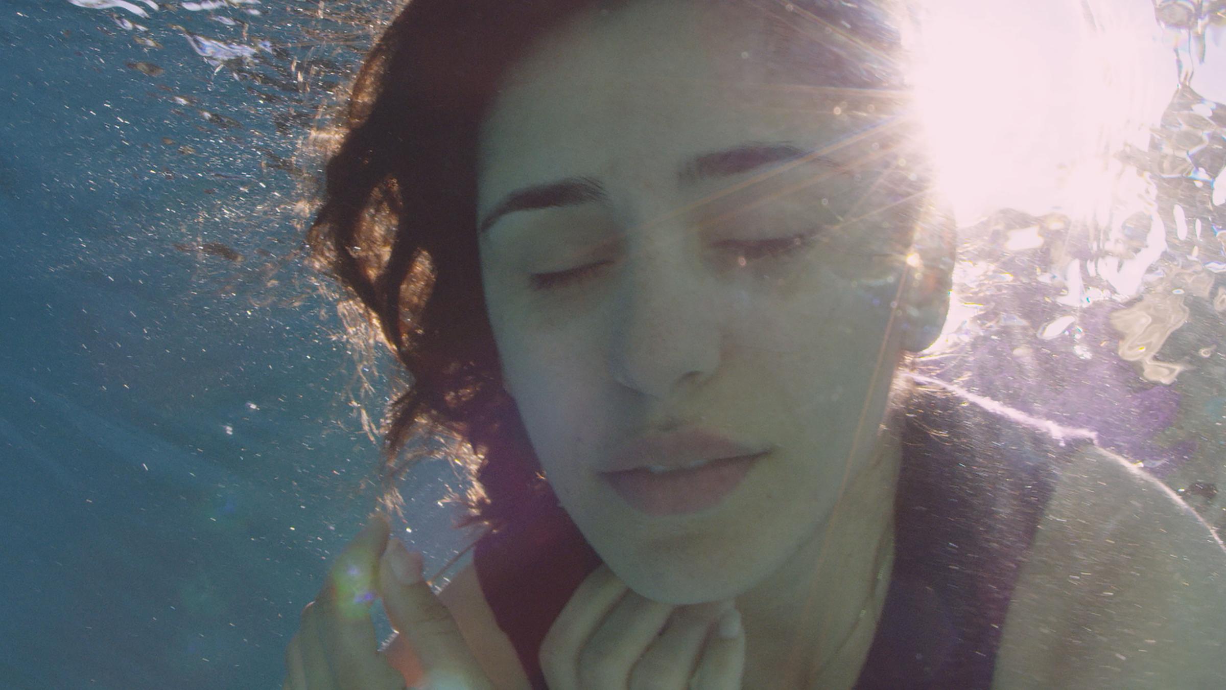 Das Gesicht einer Frau, die ins Wasser eingetaucht ist.