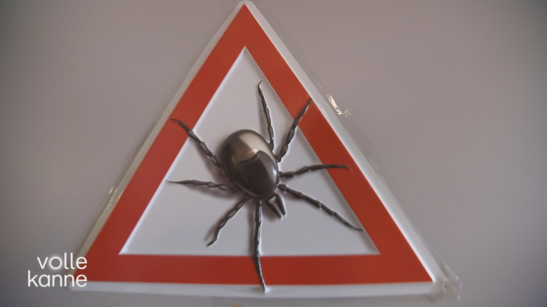 Eine Zecke als Symbol auf einem roten Schild