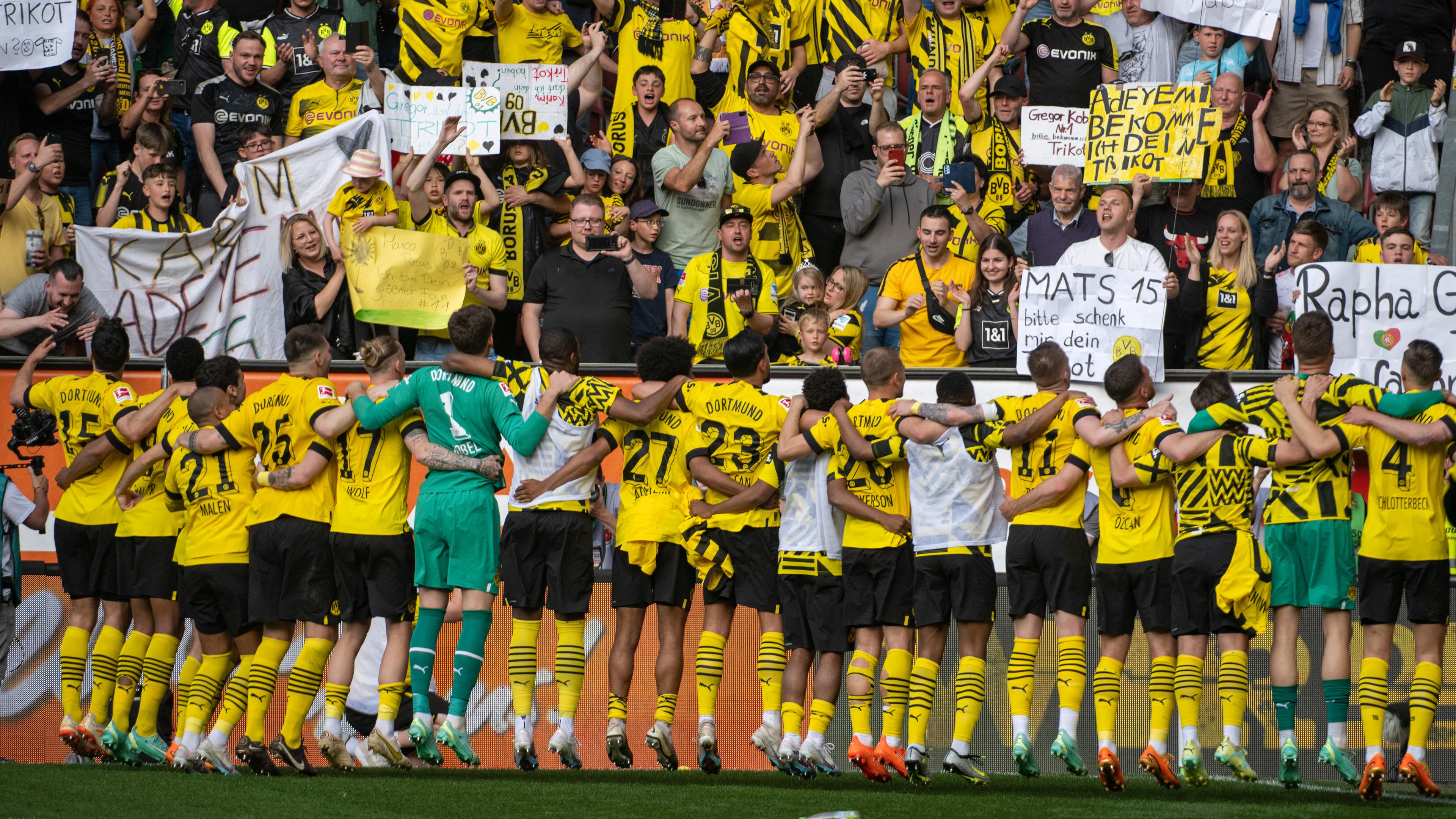 Die Mannschaft des BVB triumphiert mit ihren Fans nach dem Sieg gegen Augsburg.