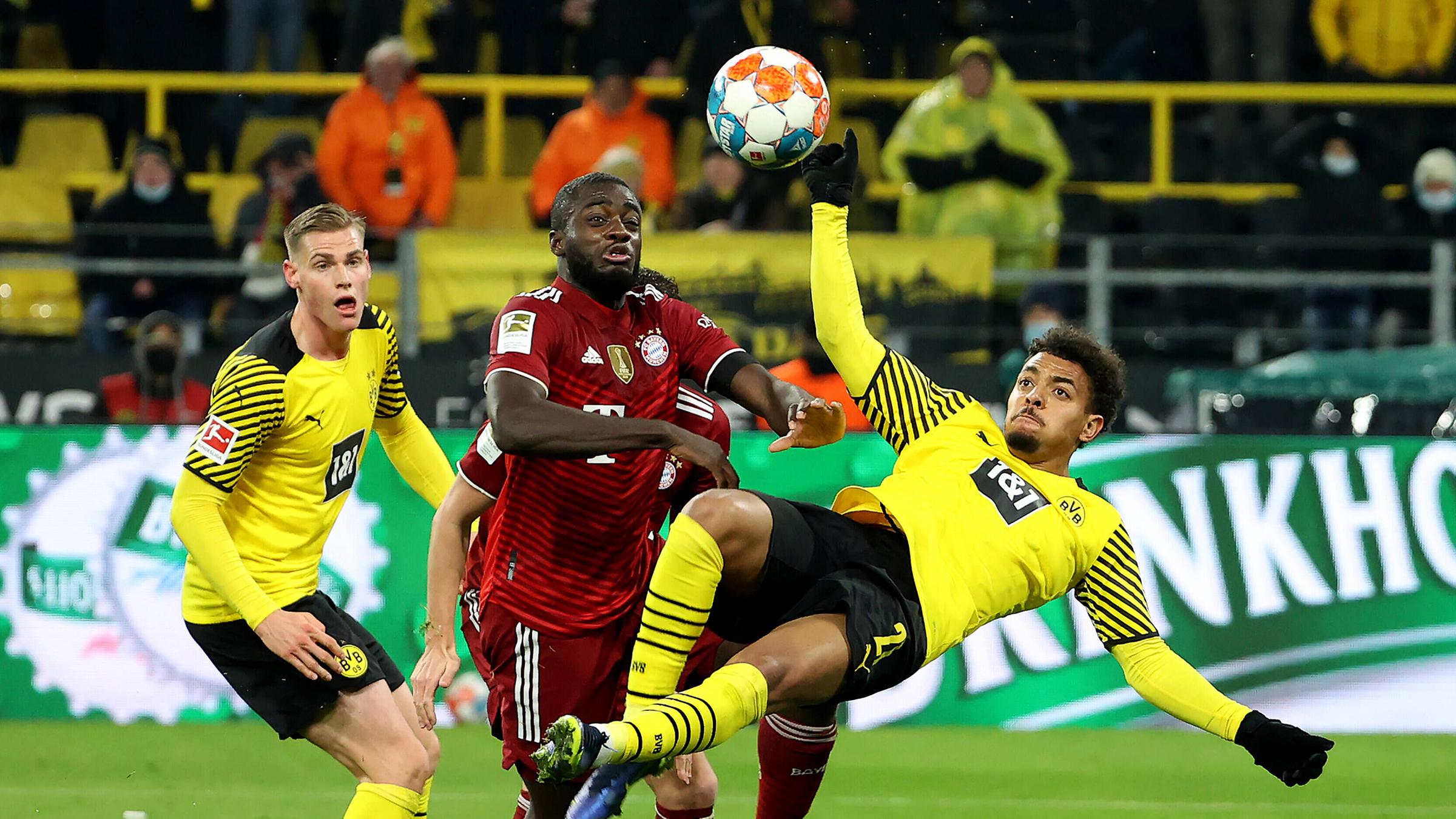 Dayot Upamecano (FC Bayern Muenchen) kämpft mit Donyell Malen (Borussia Dortmund) um den Ball.