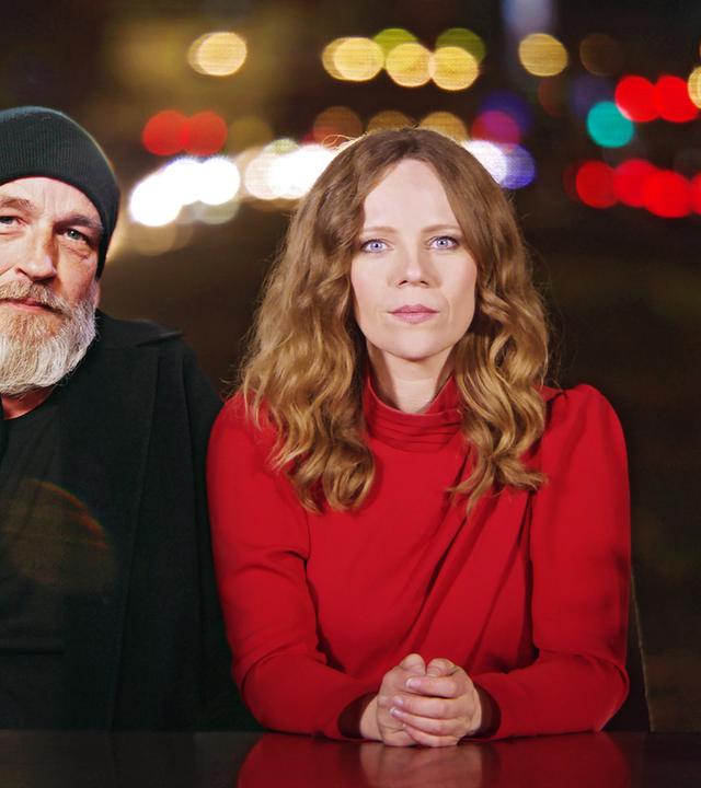 Auf dem Bild ist Sarah Bosetti auf der rechten Seite zu sehen. Links neben ihr sitzt Torsten Sträter. Beide sitzen hinter einen Schreibtisch.