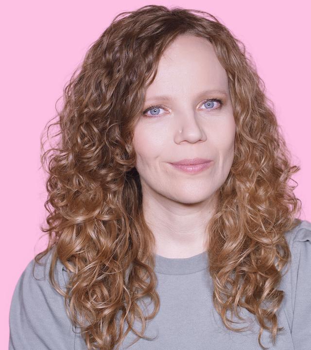 Sarah Bosetti befindet sich vor einem rosa Hintergrund. Rechts von ihr in einer Blase ist Jens Spahn abgebildet.