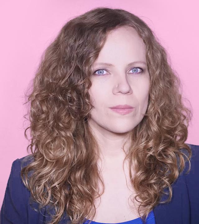 Sarah Bosetti befindet sich vor einem rosa Hintergrund. Rechts von ihr in einer Blase ist Angela Merkel abgebildet.