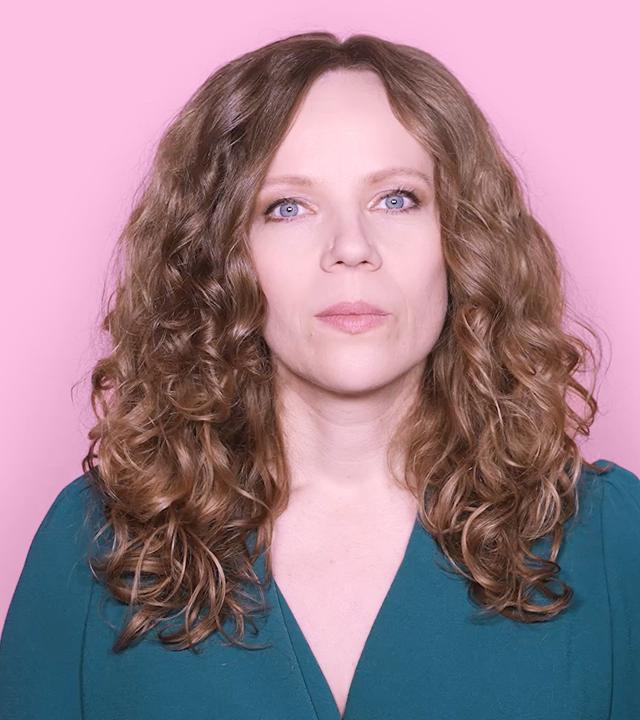 Sarah Bosetti befindet sich vor einem rosa Hintergrund. Rechts von ihr in einer Blase ist Friedrich Merz abgebildet.