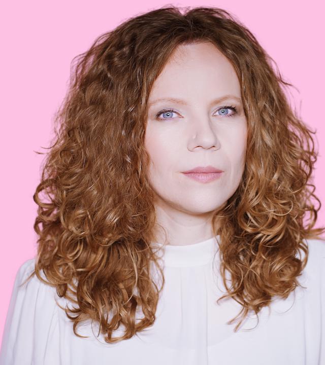Sarah Bosetti befindet sich vor einem rosa Hintergrund. Rechts von ihr sind in drei Blasen Katherina Reiche, Karoline Leavitt sowie ein bearbeitetes Foto von Katherina Reiche mit blonden Haaren abgebildet.