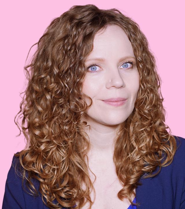 Sarah Bosetti befindet sich vor einem rosa Hintergrund. Rechts von ihr in einer Blase ist Karoline Leavitt abgebildet.