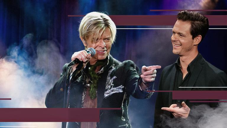Jo Schück betrachtet ein Bild des Musikers David Bowie