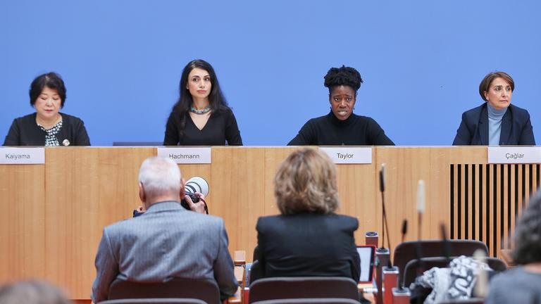 Vier Frauen sitzen vor der blauen Wand in der Bundespressekonferenz.