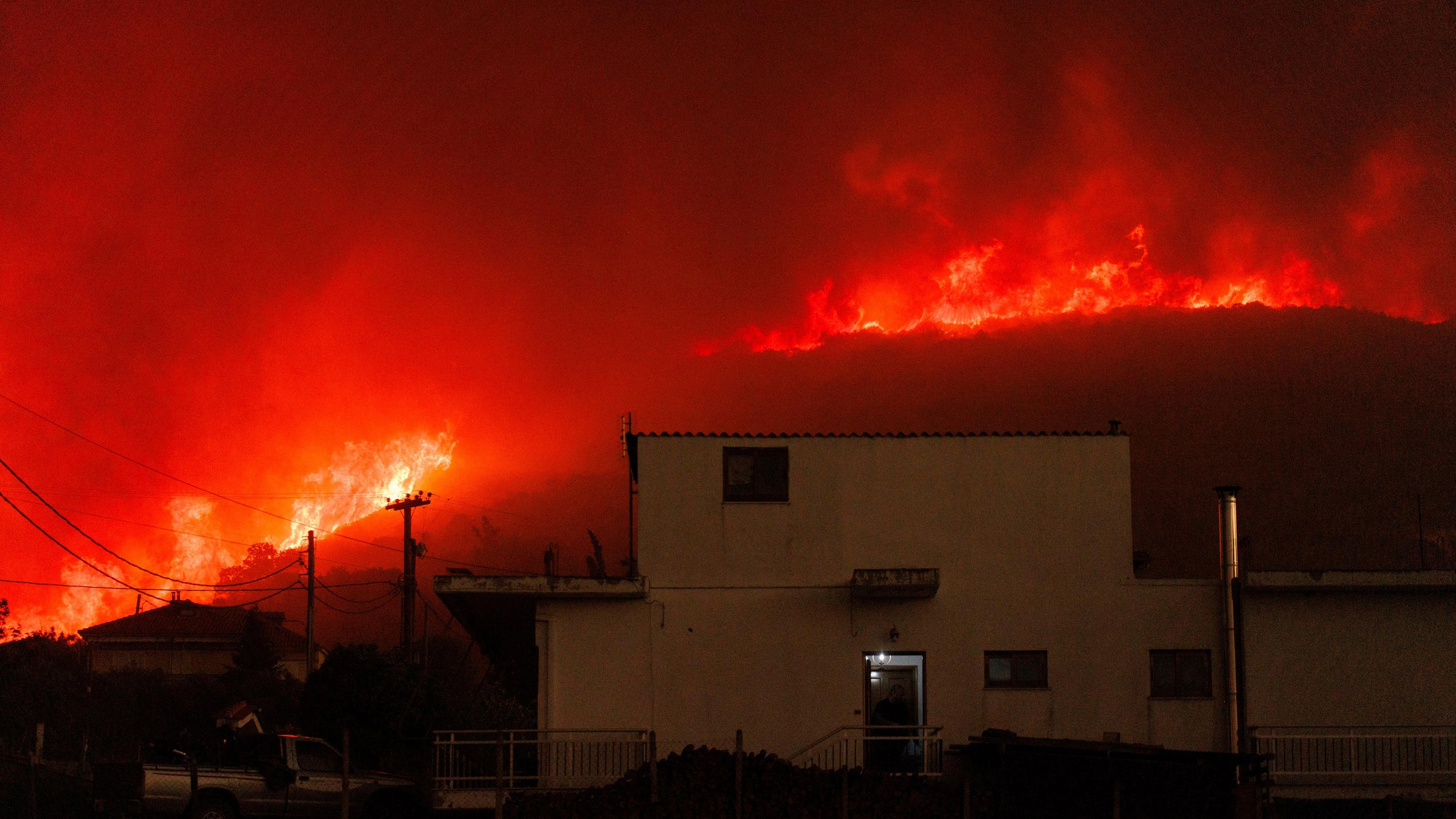 Griechenland, Avantas: Ein Waldbrand brennt in der Nähe eines Hauses im Dorf Avantas in der Nähe der Stadt Alexandroupolis in der nordöstlichen Region Evros.