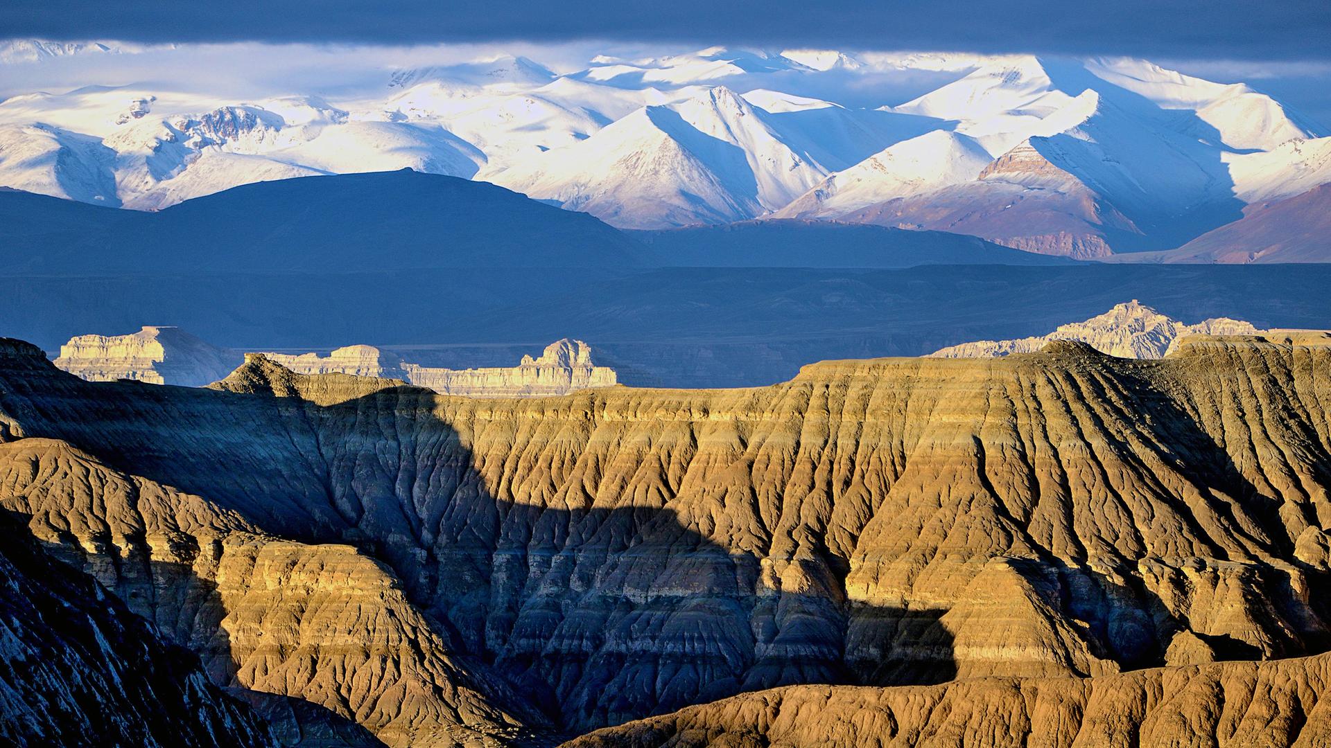 Steinfelsen vor schneebedecktem Gebirge