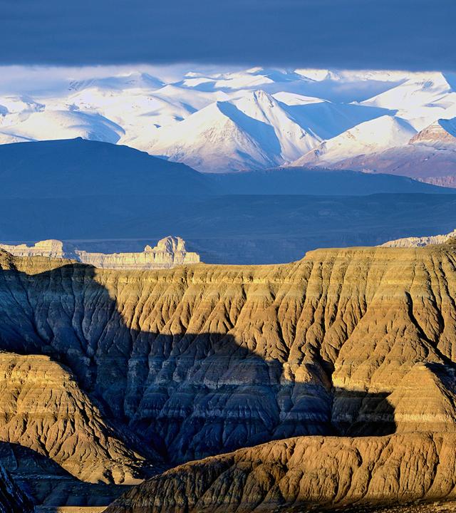 Steinfelsen vor schneebedecktem Gebirge