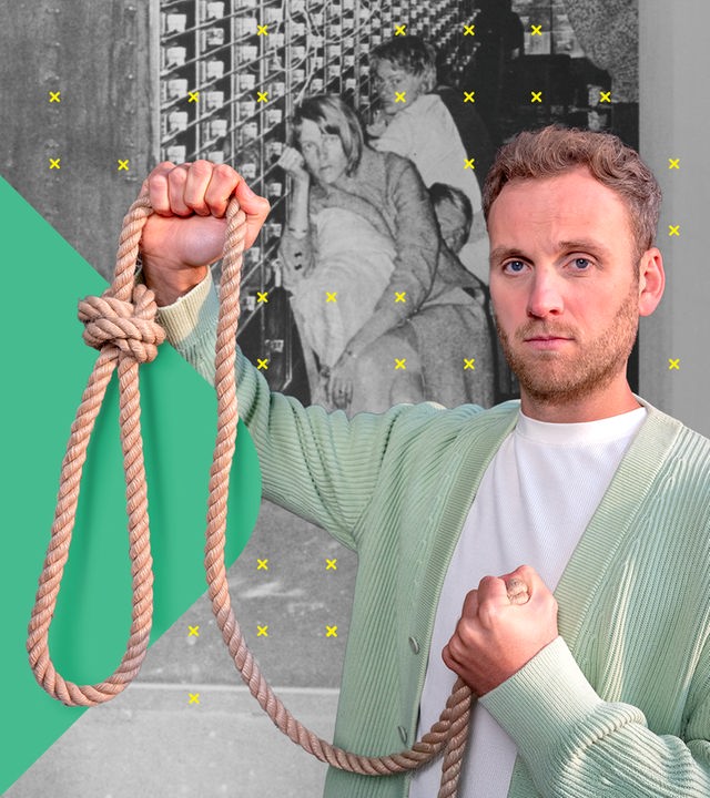 Dr. Leon Windscheid steht vor einer historischen Schwarz-Weiß-Aufnahme, die mehrere sitzende Menschen zeigt. Er hält in der rechten Hand ein Stück Seil mit einer Schlinge und blickt dabei ernst in die Kamera