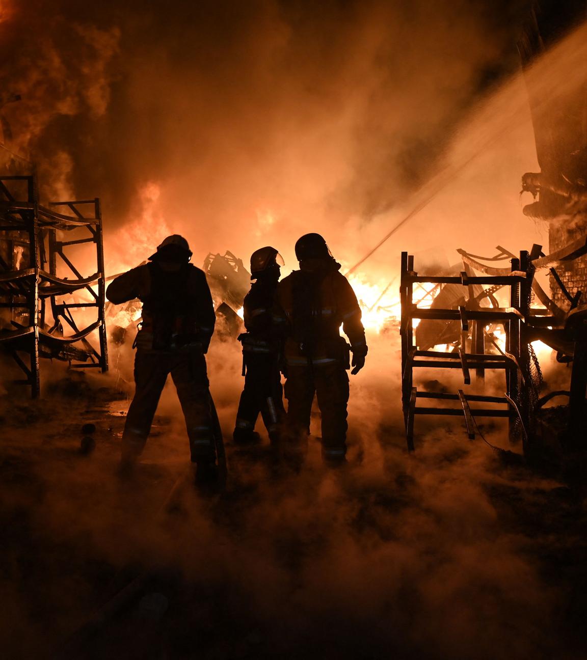 Ukrainische Feuerwehrleute löschen ein Feuer am Ort eines Drohnenangriffs auf Industrieanlagen in Charkiw am 04.05.2024