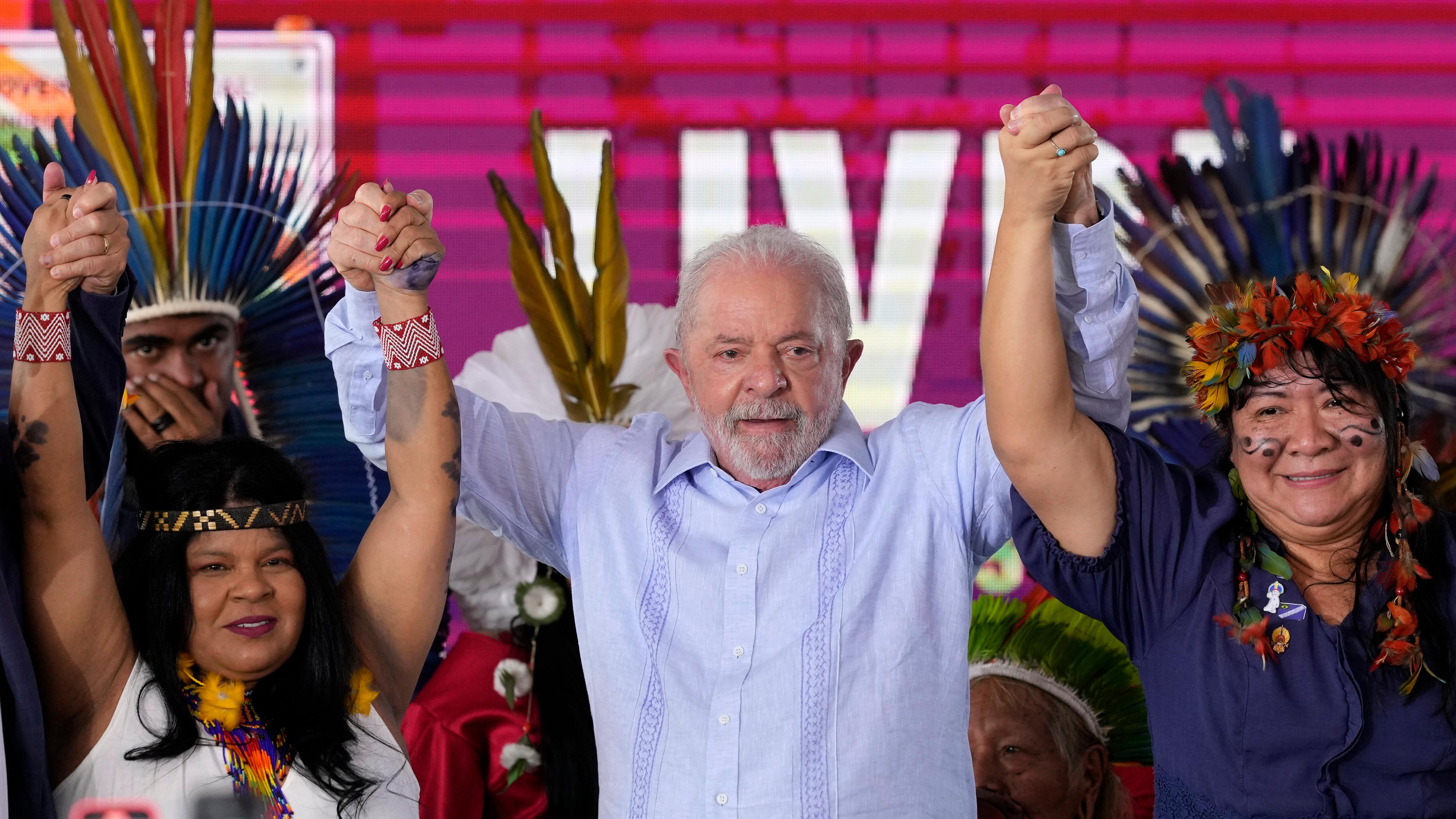Brasiliens Präsident Luiz Inacio Lula da Silva mit zwei indigenen Frauen links und rechts von ihm. Sie feiern die Erschaffung sechs neuer Schutzgebiete für indigene Einwohner