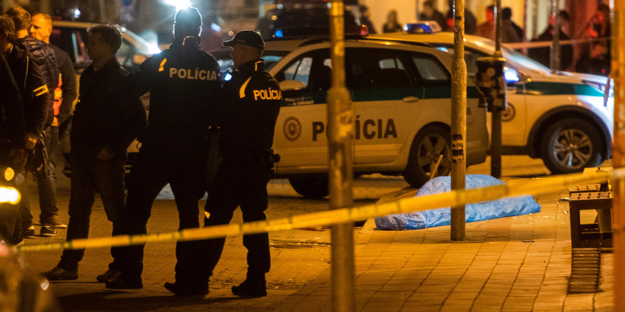 Polizisten stehen am Tatort nach Schüssen vor einer Bar in der Zámocká-Straße