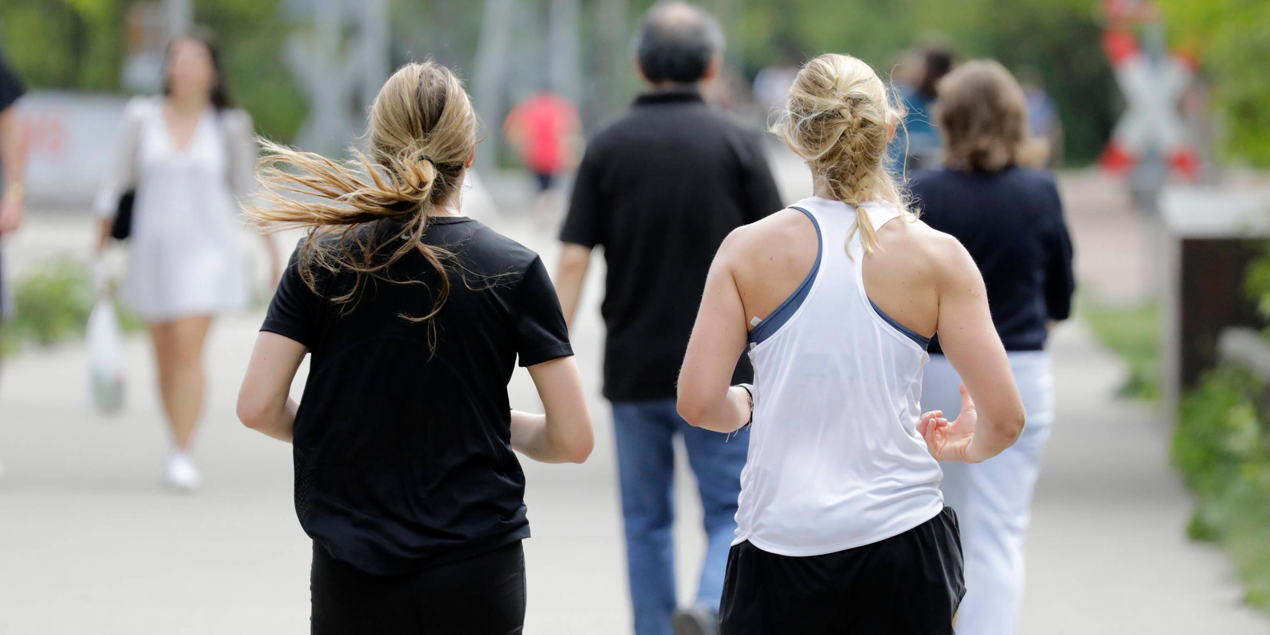 Zwei Joggerinnen joggen bei sommerlichen Temperaturen und Sonnenschein im Park am Gleisdreieck am 10.05.2020 in Berlin