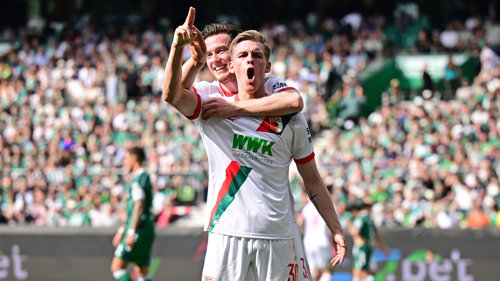 Anton Kade (FC Augsburg, Torschütze) jubelt mit Michael Gregoritsch (l.) im Spiel gegen Werder Bremen.