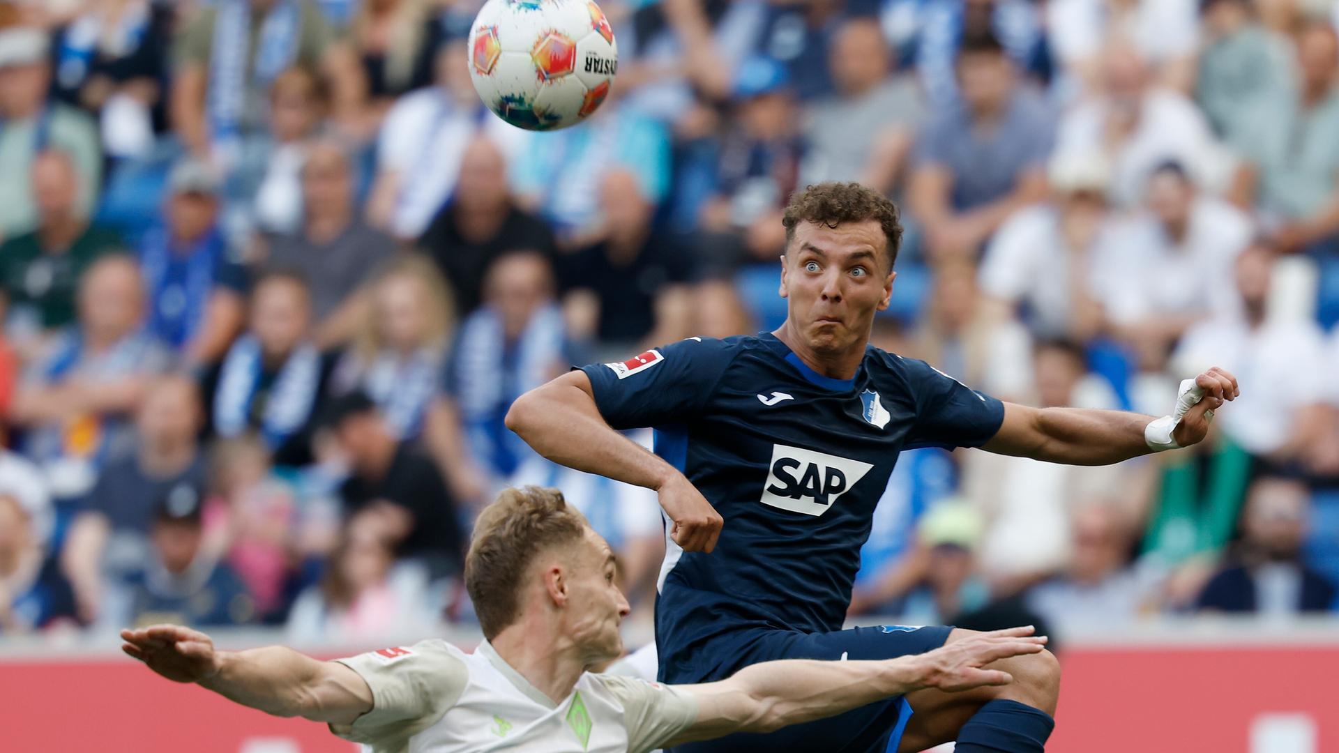 Hoffenheims Mittelstürmer Fisnik Asllani setzt im Zweikampf mit Bremens Innenverteidiger Amos Pieper zum Kopfball an