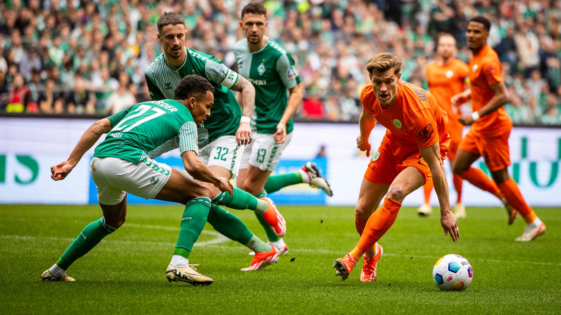 Bremens Felix Agu und Wolfsburgs Kevin Behrens im Kampf um den Ball am 30.03.2024.