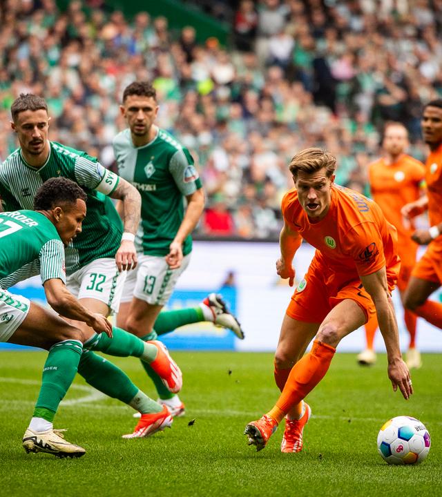 Bremens Felix Agu und Wolfsburgs Kevin Behrens im Kampf um den Ball am 30.03.2024.