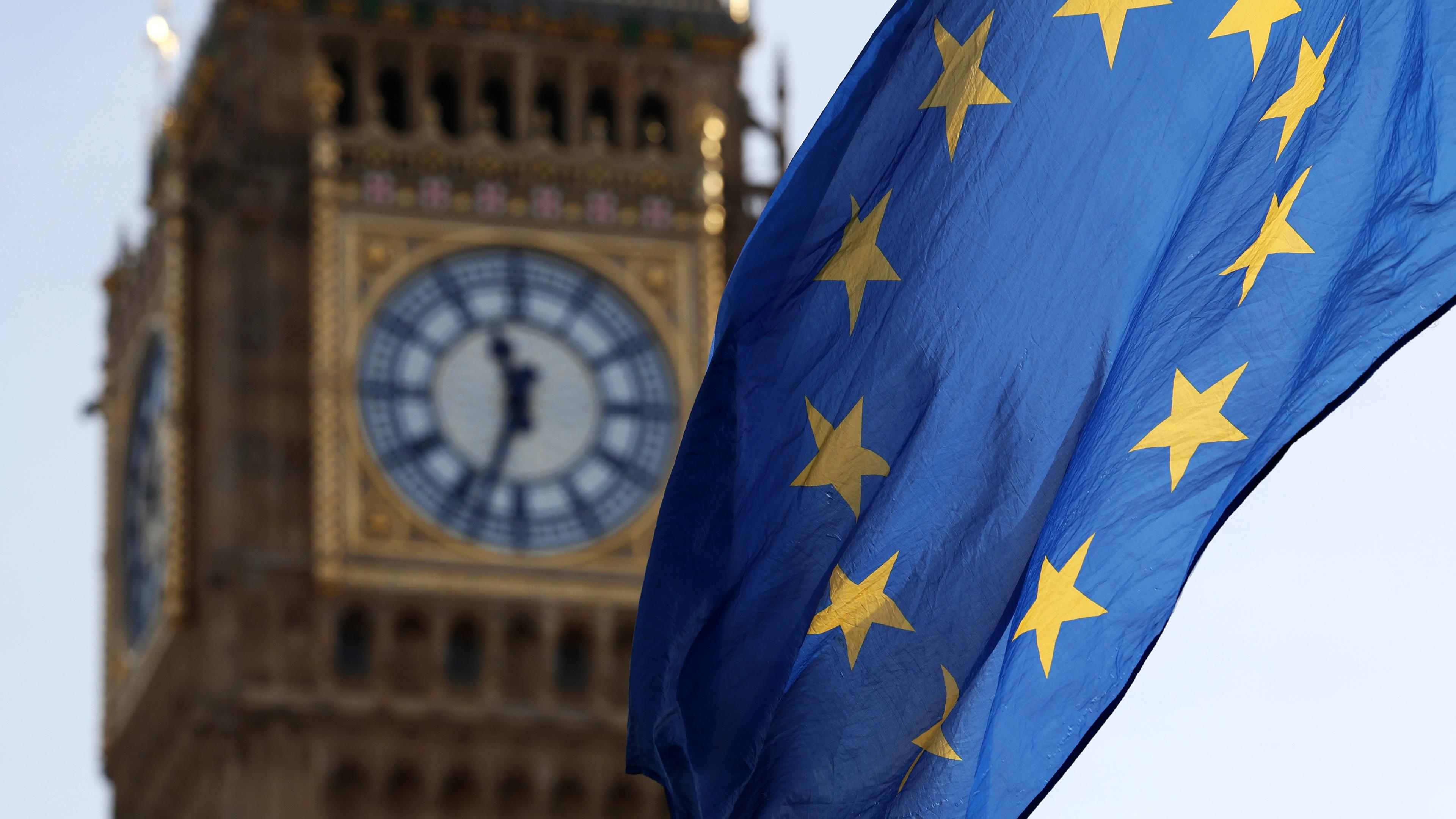 Es ist der Big Ben Glockenturm in London zu sehen und davor weht die Flagge der EU