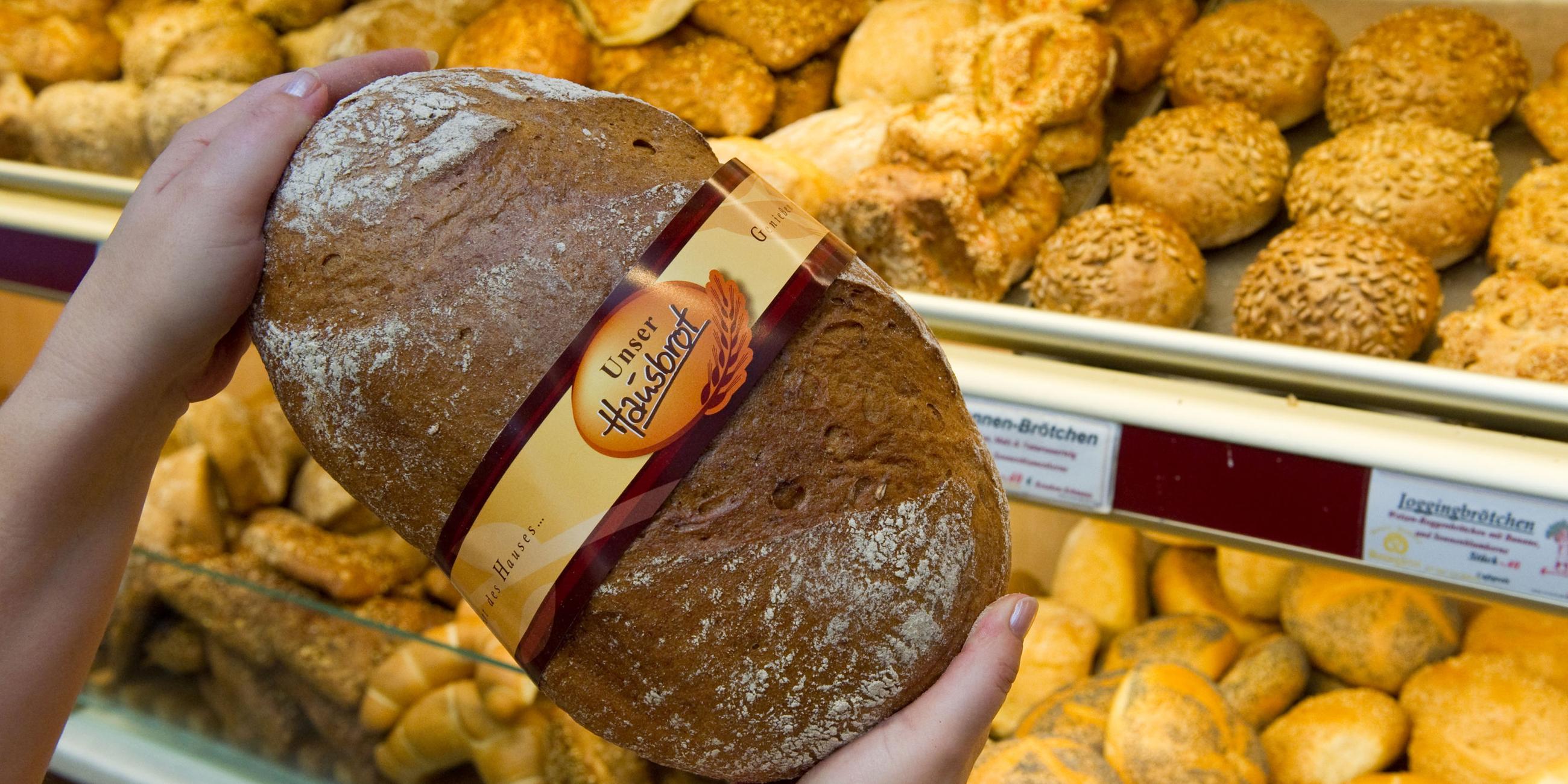 Eine Verkäuferin zeigt ein Brot in einer Bäckerei