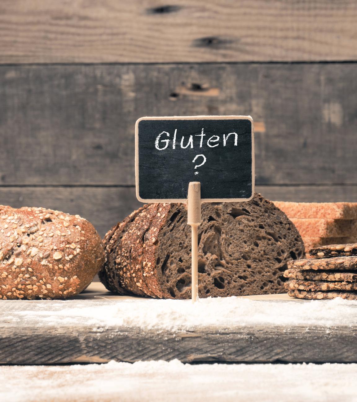Eine kleine Tafel mit der Aufschrift Gluten ist vor verschiedenen Brotsorten aufgestellt.