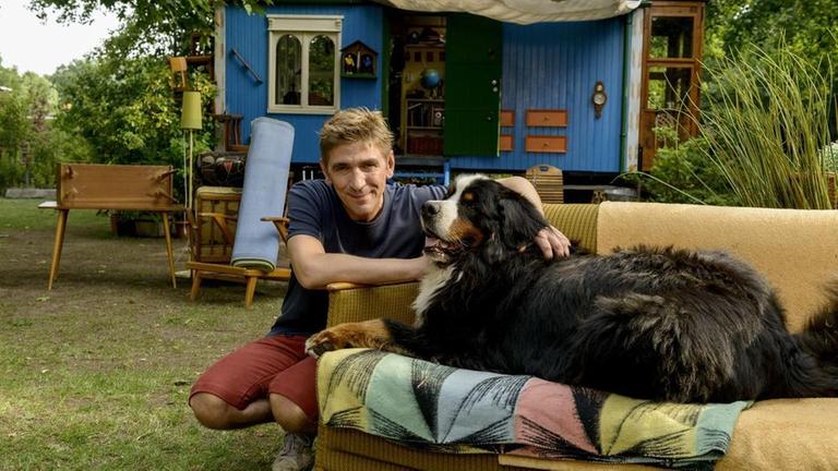 Fritz Fuchs (Guido Hammesfahr) und Hund Keks vor ihrem Zuhause, dem blauen Bauwagen.