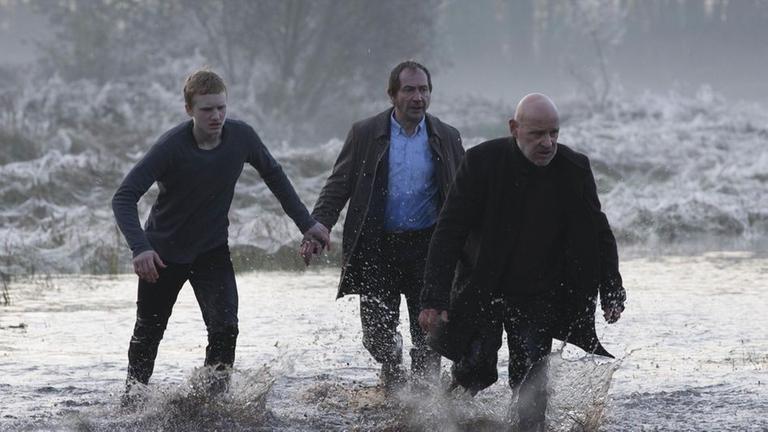 Peter F�hnrich (Sammy Scheuritzel), Fichte (Thorsten Merten) und Kommissar Kr�ger (Christian Redl) laufen durch das �berflutete Feld.