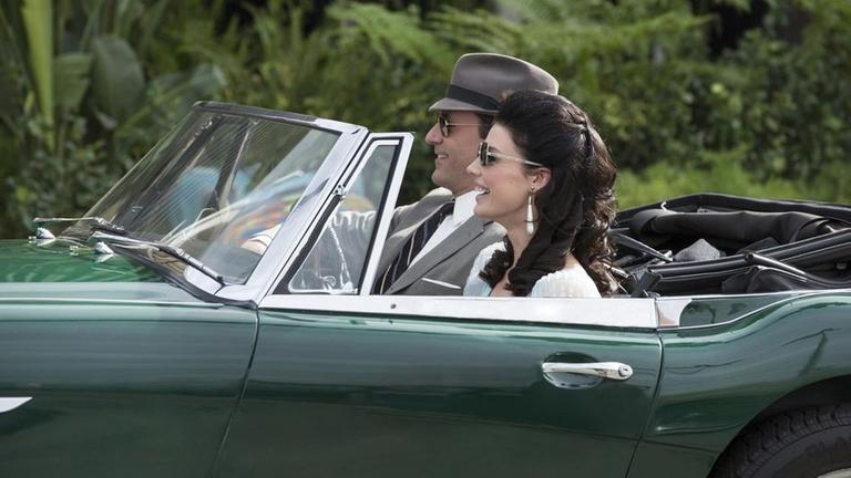 Don Draper (Jon Hamm, l.) nutzt seinen unfreiwilligen Urlaub um seine Frau Megan Draper (Jessica Pare, r.) in Kalifornien zu besuchen. In der Ehe der beiden kriselt es seit einiger Zeit.
