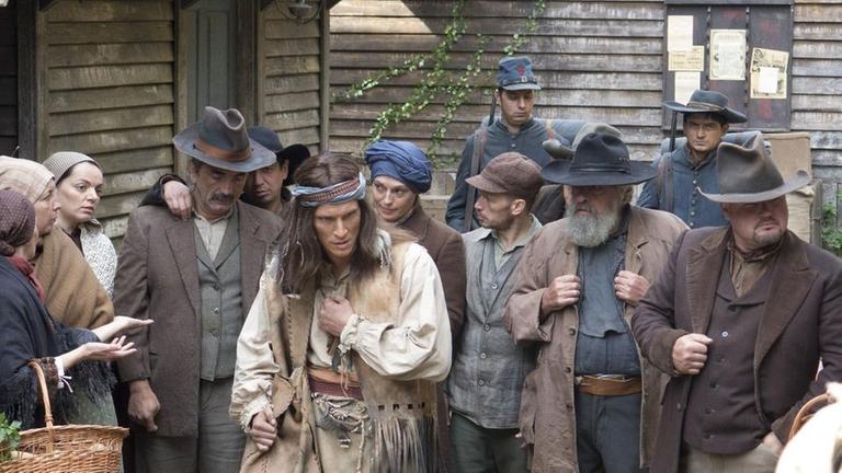 Gekleidet als Indianer, wird Herman Lehmann (alias Montechema) von den Bewohnern Loyal Valleys mit Misstrauen und Neugier empfangen (Spielszene).