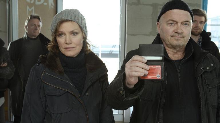 Die Kommissare Verena Berthold (Maja Maranow, l.) und Otto Garber (Florian Martens, r.) treffen bei der Eigent�merversammlung ein. Hier hasst jeder Dietmar Jacobs, weil sie wegen ihm in Rohbauten wohnen m�ssen und am Rand ihrer finanziellen Belastungsgrenze stehen.