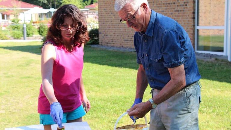 Frau und Mann arbeiten im Garten.