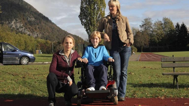 Ella Herlinger (Petra Schmidt-Schaller, l.), Johanna Mosbach (Anna Schudt, r.) und deren an Duchenne erkrankter Sohn Lennart (Joshua van Dalsum, M.)