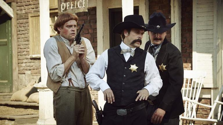 Praktikant Christopher (Max Giermann, l.) im Wilden Westen beim Gunfight am OK Choral, zusammen mit Wyatt Earp (Matthias Matschke, M.) und Virgil Earp (Holger Stockhaus, r.).