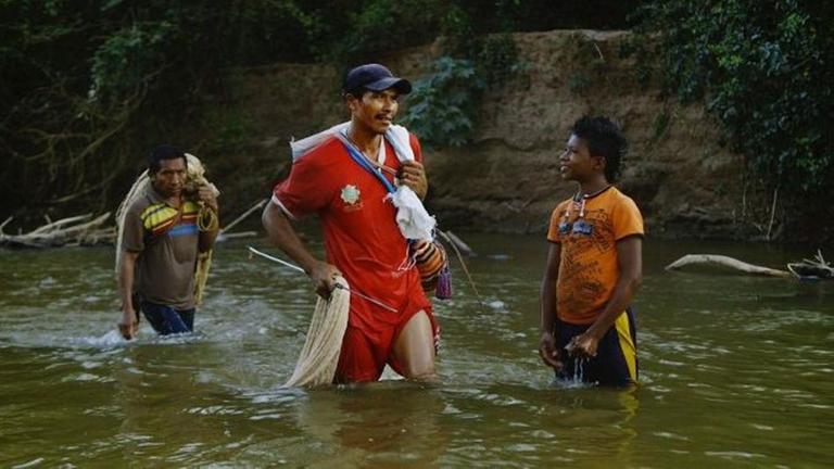 "La Buena Vida - Das gute Leben"(3sat): Drei Angehörige der Wayúus stehen knietief in einem Fluss. Zwei tragen Fischernetze und -ausrüstung.
