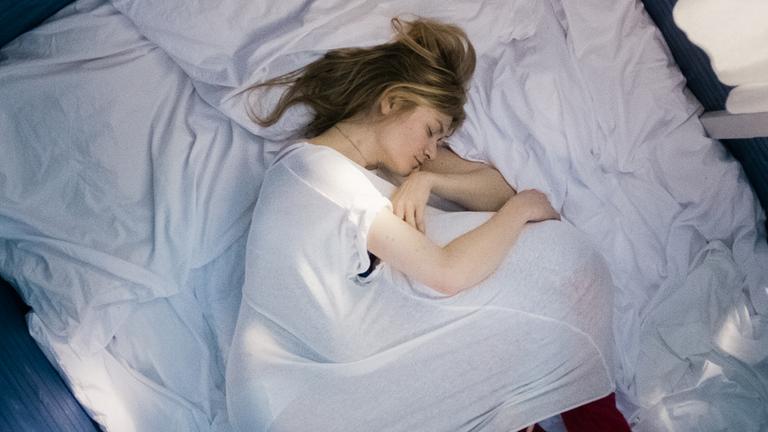 "24 Wochen": Astrid (Julia Jentsch) liegt mit angezogenen Beinen schlafend auf dem Bett