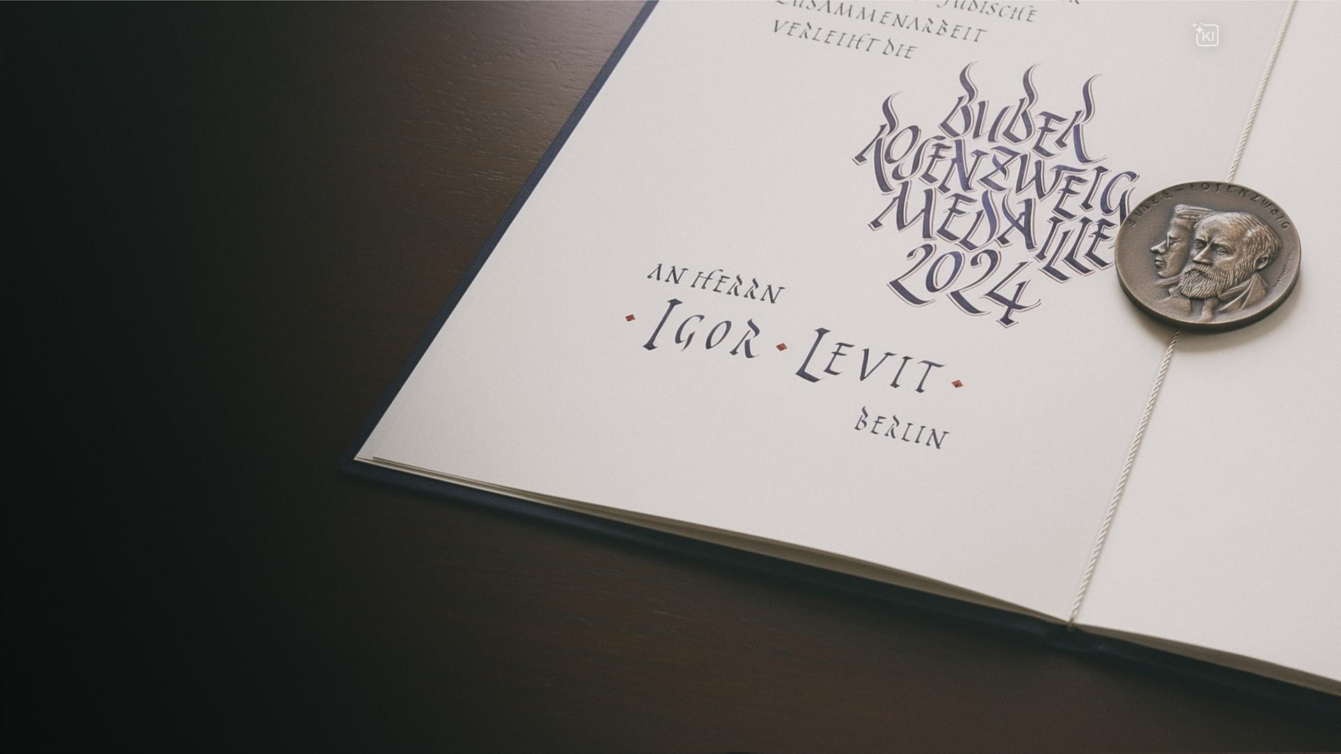 Eine aufgeschlagene Buchseite, auf der eine silberne Medaille liegt.