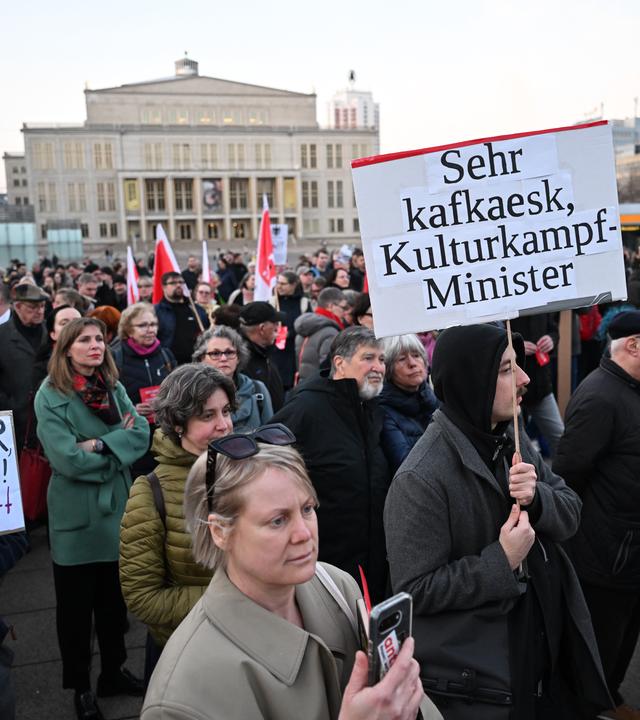Menschens stehen mit Plakaten vor dem Gewandhaus in Leipzig. Aufschrift: Sehr Kafkaesk, Herr Kulturkampf-Minister