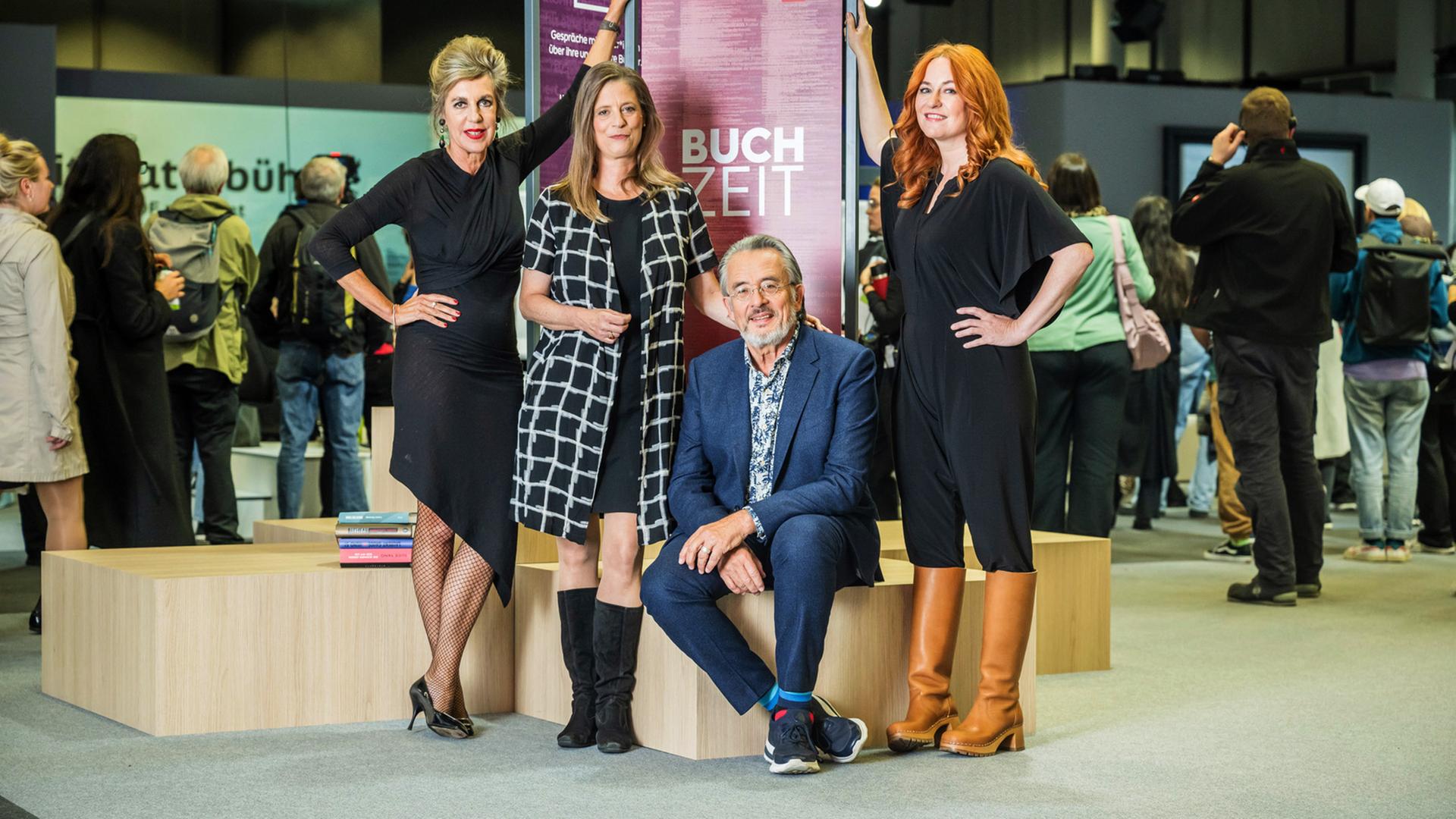 Das Buchzeitteam Barbara Vinken, Sandra Kegel, Gert Scobel und Katrin Schumacher vor einem Buchzeit-Aufsteller auf der Frankfurter Buchmesse 2023.