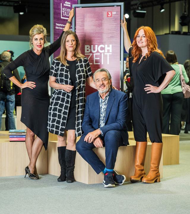 Das Buchzeitteam Barbara Vinken, Sandra Kegel, Gert Scobel und Katrin Schumacher vor einem Buchzeit-Aufsteller auf der Frankfurter Buchmesse 2023.