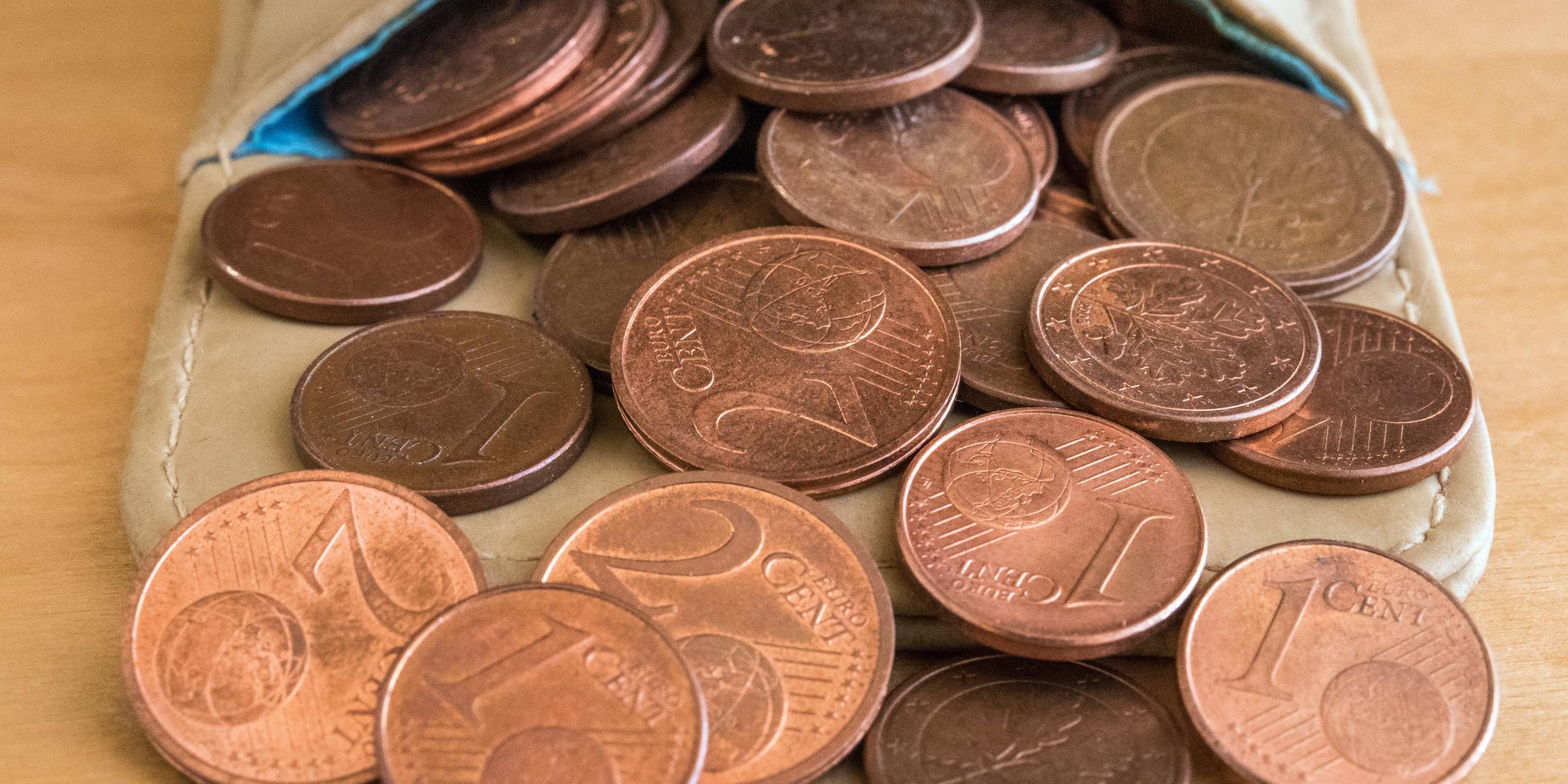 Verschiedene Euro-Cent-Münzen in einem Beutel auf einem Tisch