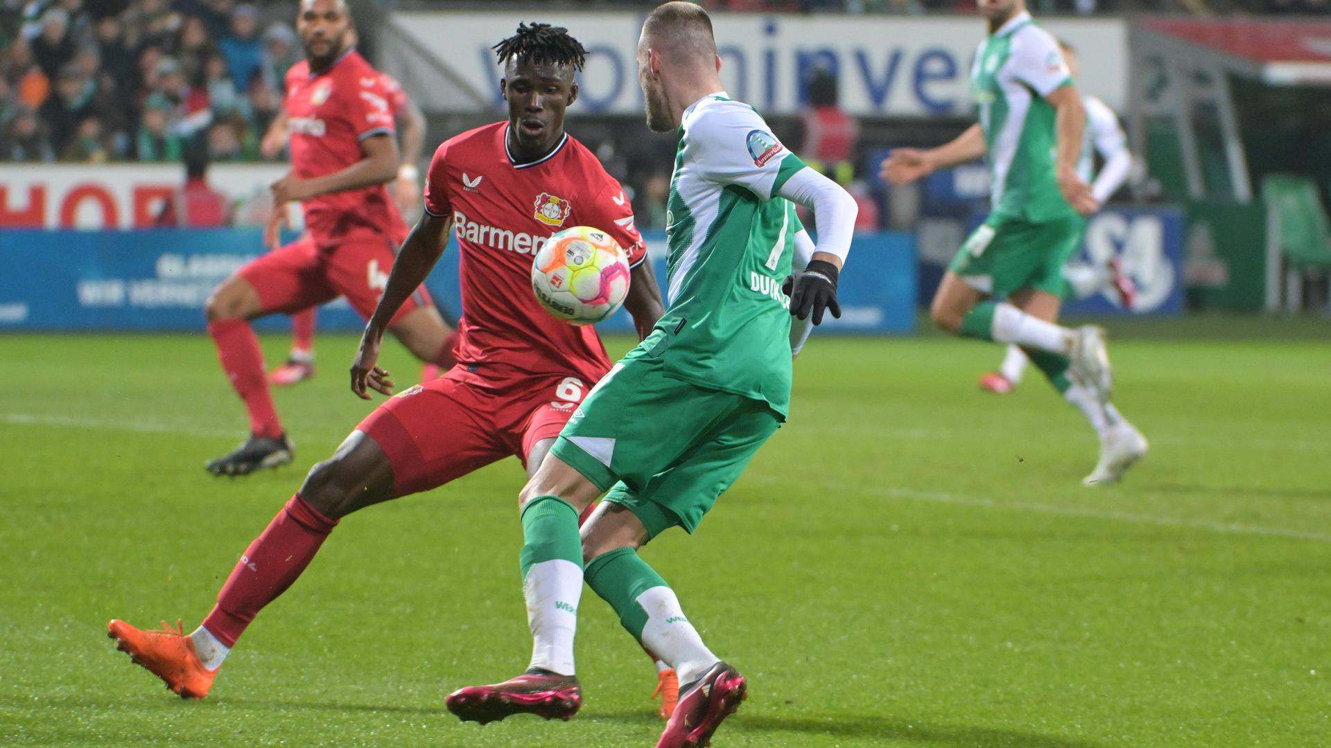 12.03.2023, Bremen: Zweikampf Odilon Kossounou (Bayer 04 Leverkusen 6) und Marvin Duksch (SV Werder Bremen)