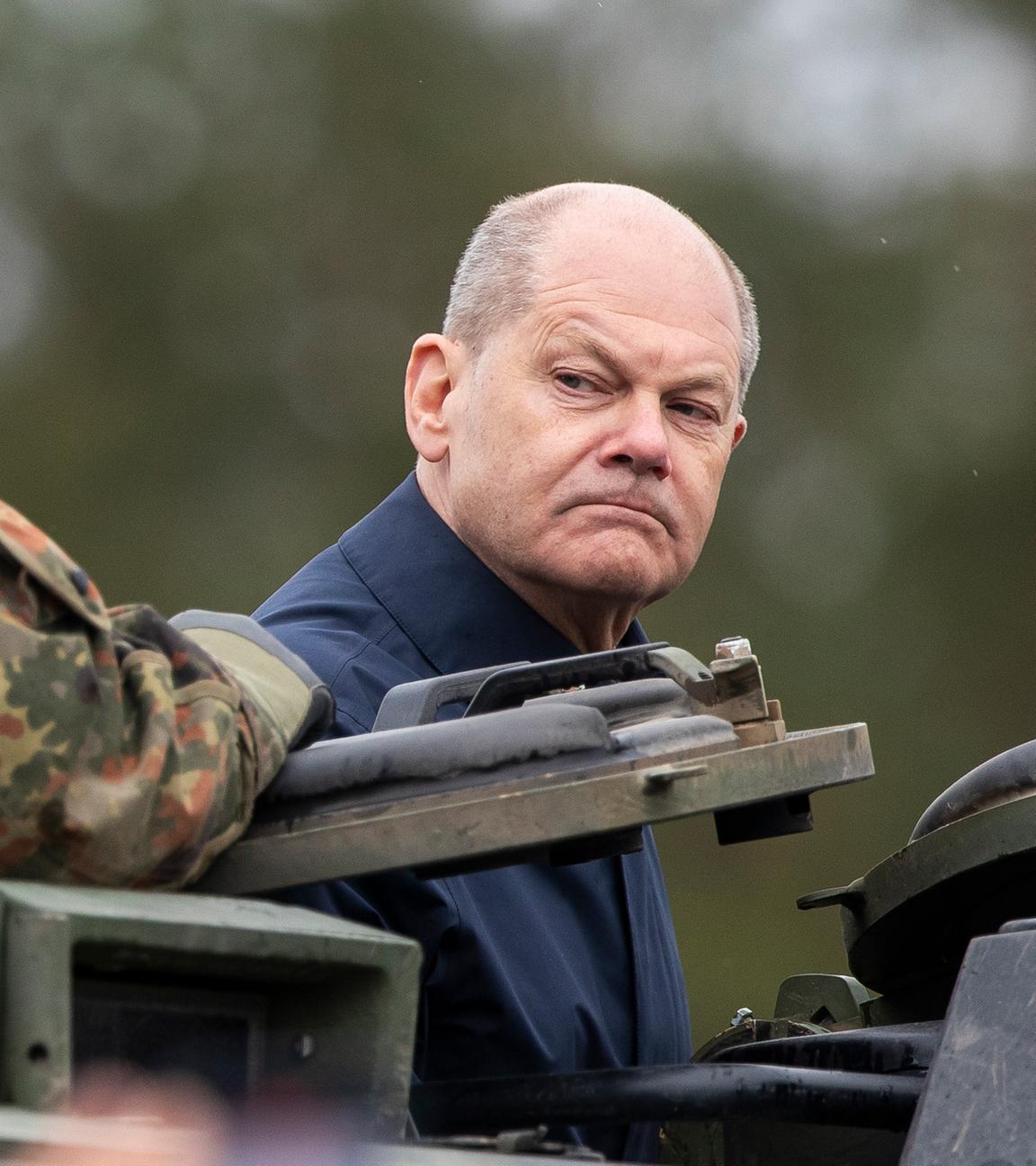 Litauen, Vilnius: Bundeskanzler Olaf Scholz (SPD) fährt auf einem gepanzerten Militärfahrzeug während der litauisch-deutschen Militärübung "Grand Quadriga" auf einem Truppenübungsplatz in Pabrade.