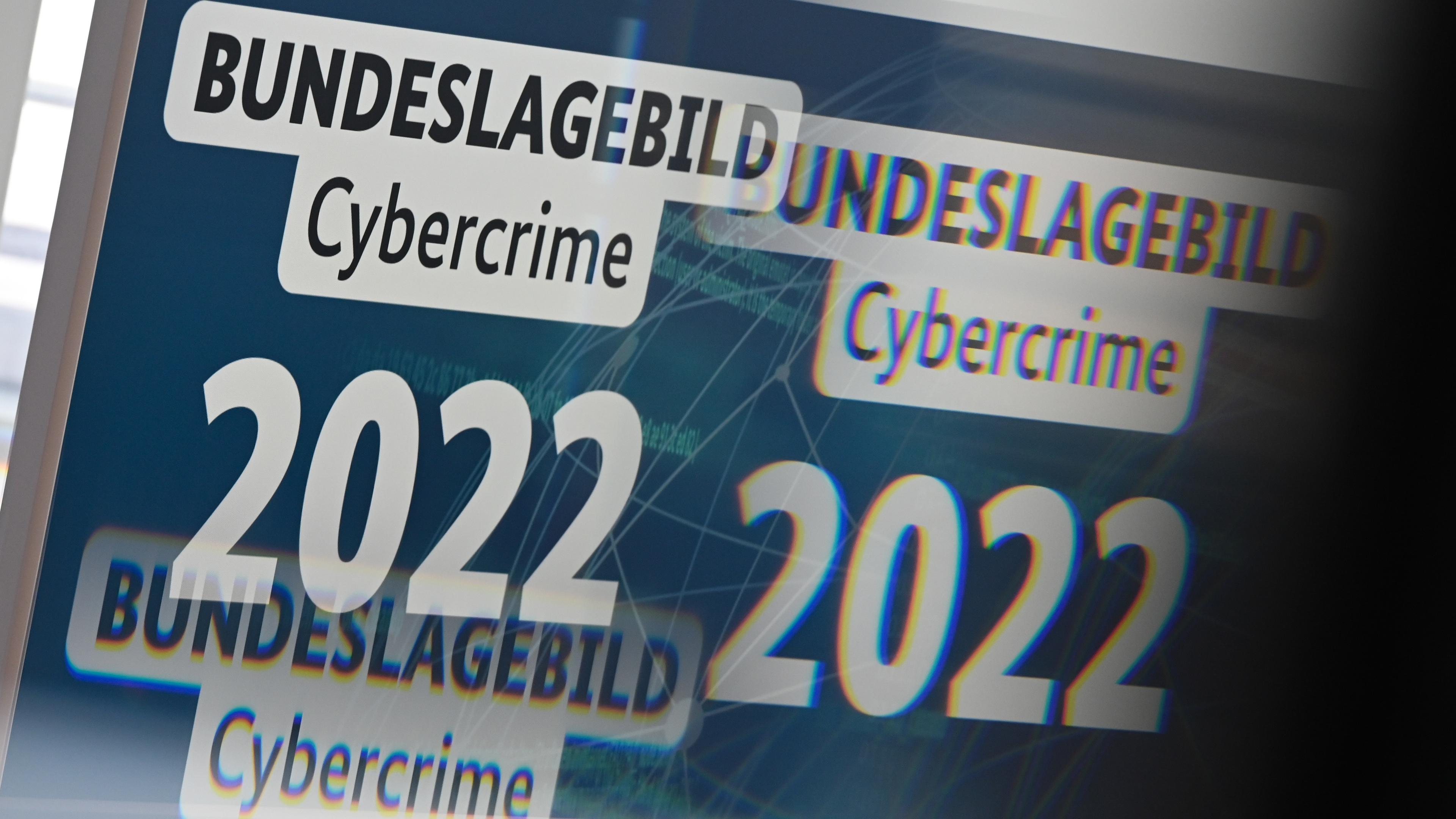 Durch eine Glasscheibe ist im Bundeskriminalamt (BKA) bei der Vorstellung des "Bundeslagebild Cybercrime 2022" von BKA und Branchenverband Bitkom ein Monitor zu sehen.