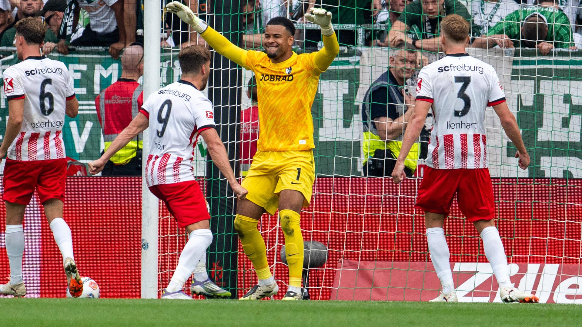 Freiburgs Torwart Noah Atubolu jubelt mit seiner Mannschaft nach dem gehaltenen Elfmeter.