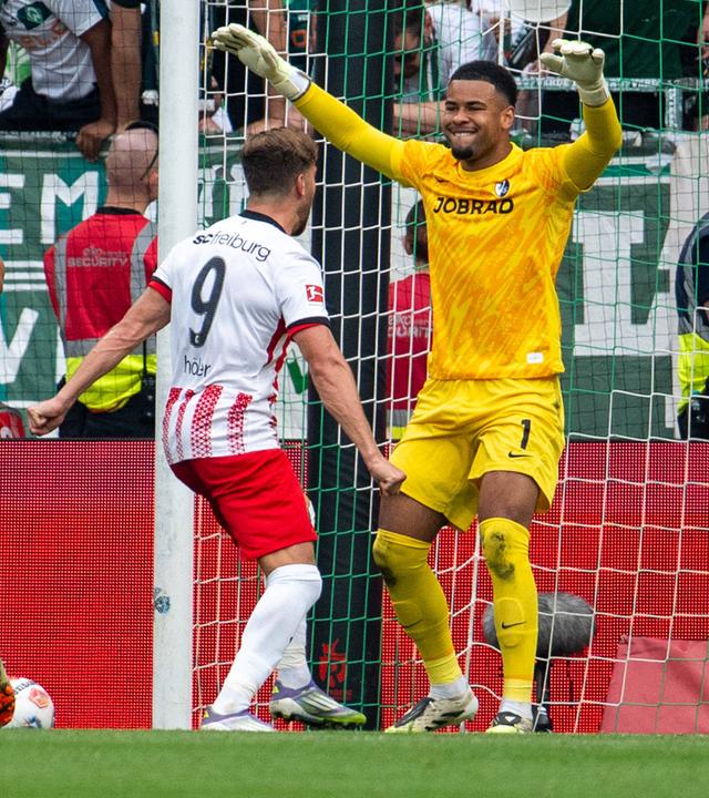 Freiburgs Torwart Noah Atubolu jubelt mit seiner Mannschaft nach dem gehaltenen Elfmeter.