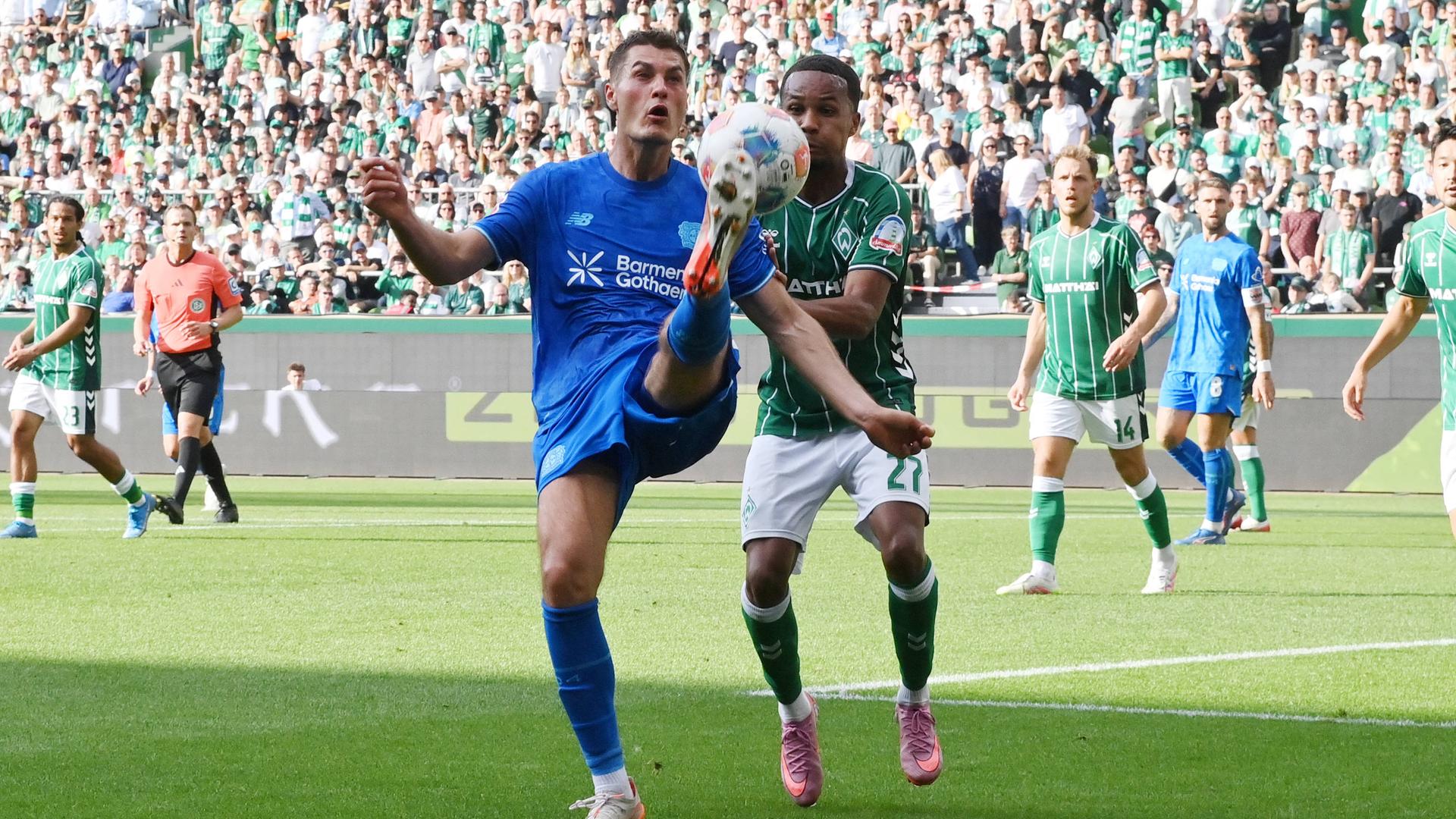 Leverkusens Patrik Schick in Aktion gegen Felix Agu von Werder Bremen.