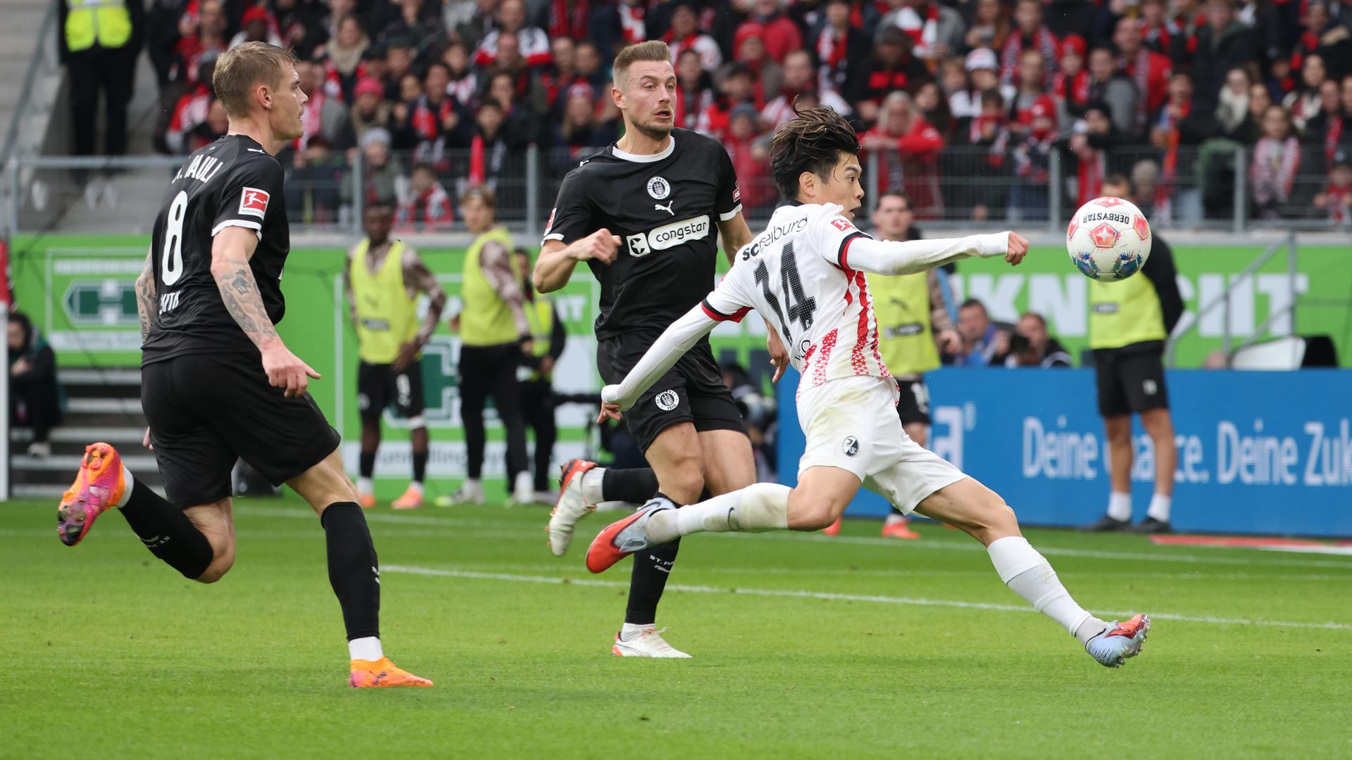 St. Paulis Eric Smith und Hauke Wahl in Aktion gegen Yuito Suzuki vom SC Freiburg.