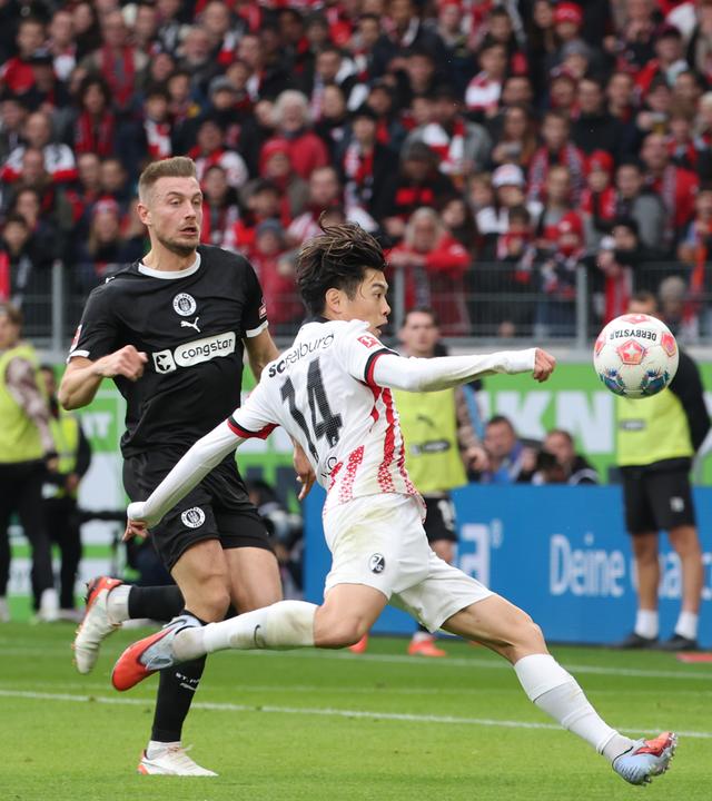 St. Paulis Eric Smith und Hauke Wahl in Aktion gegen Yuito Suzuki vom SC Freiburg.